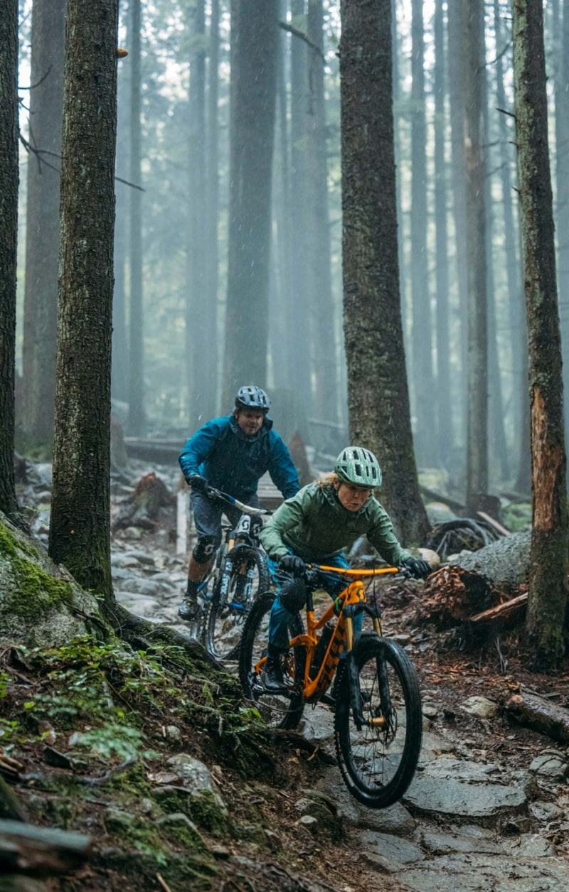 In a place that can receive 100 inches of precipitation each year, you get used to riding in the rain; after nearly 30 years, Betty actually enjoys it. Betty and Hayden navigate roots and the weather on lower Pingu—just another lovely day on the North Shore. Photo: Travis Rummel