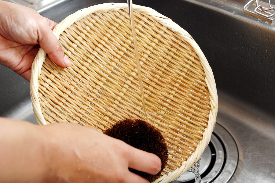 Bamboo colanders should be rinsed thoroughly with running water using a scrubbing brush.