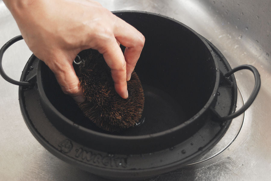 Iron pans that are not enamel coated should be cleaned with water using a scourer.