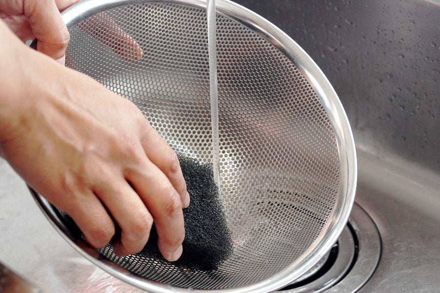 Stains on the stainless steel colander can be removed simply by scrubbing with a scrubbing brush.
