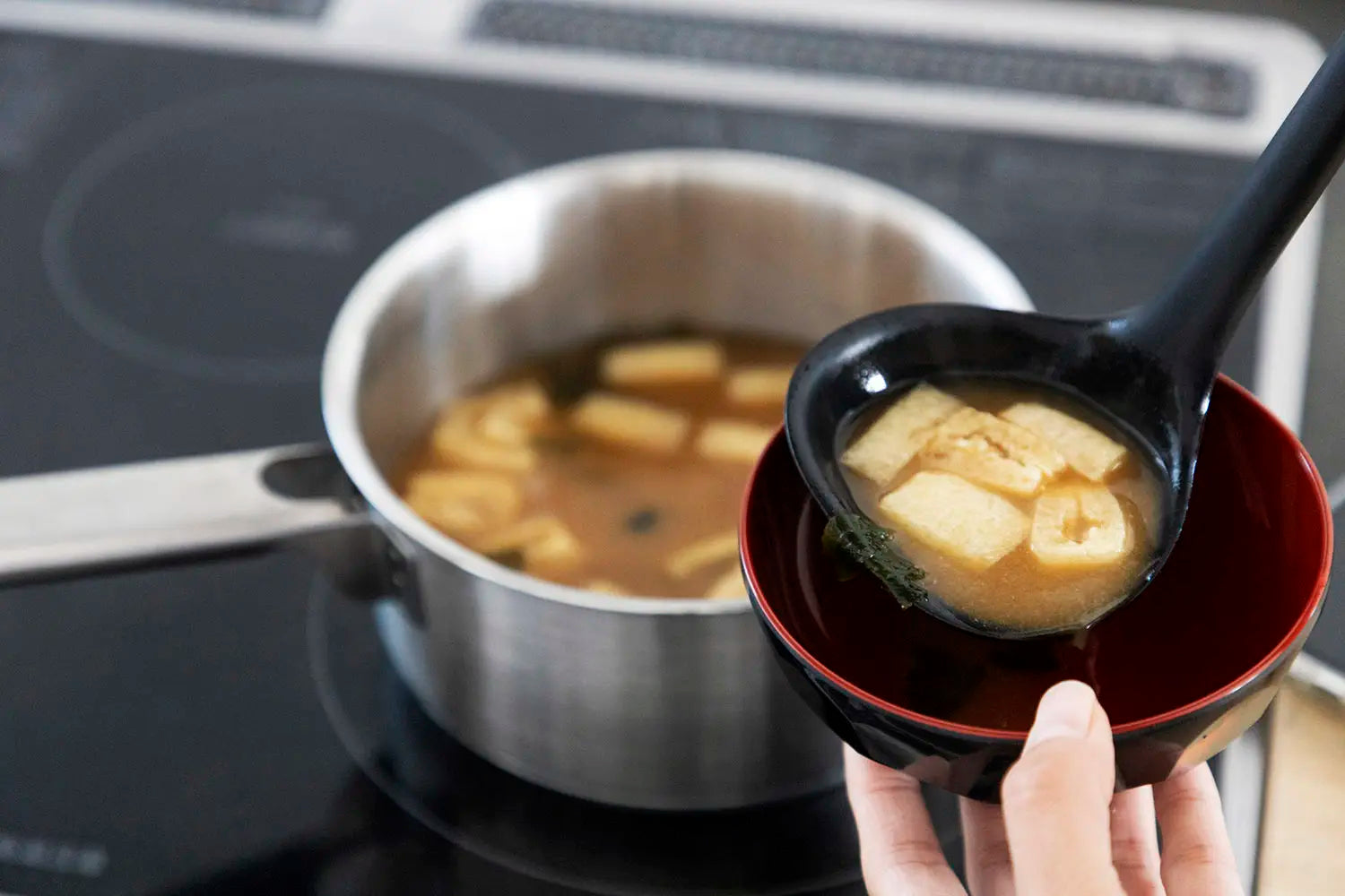 Pourijng miso soup into a bowl