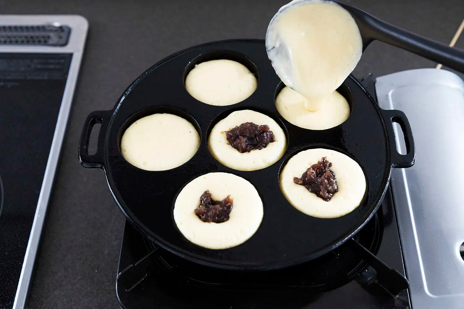 Topping off some obanyaki with filling added