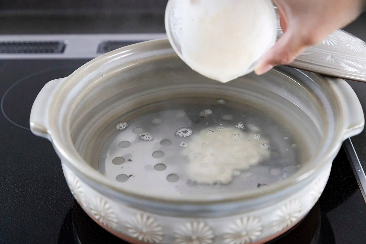 Pouring water and flour mixture into donabe water