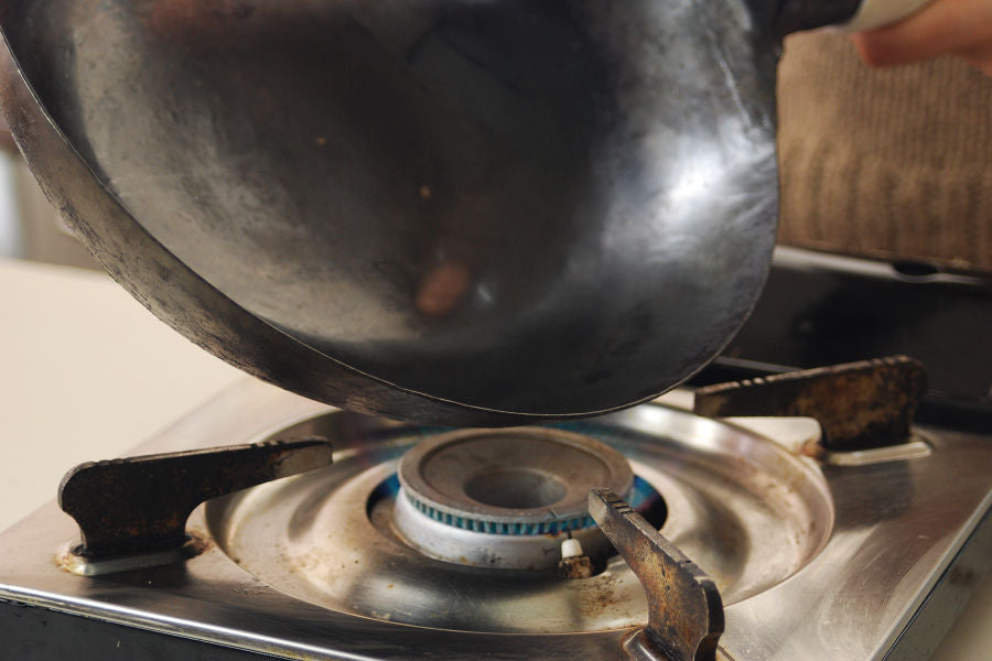 Heat an empty wok until it turns gray entirely.