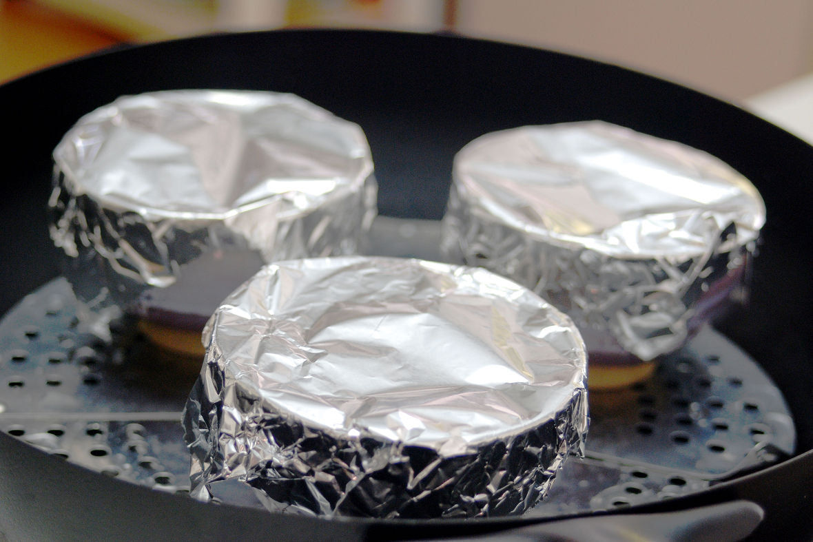 Cover the top of the cup with aluminum foil and place the cups on the one-size-fits-all steamer,
