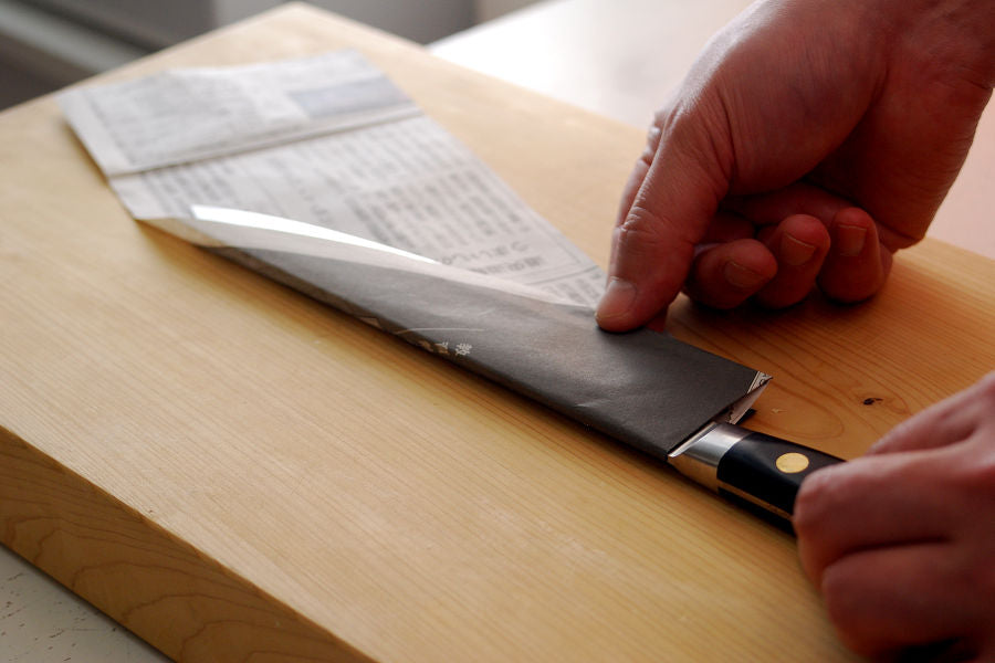 Fold the paper from the back of the knife, just like wrapping it with the paper.