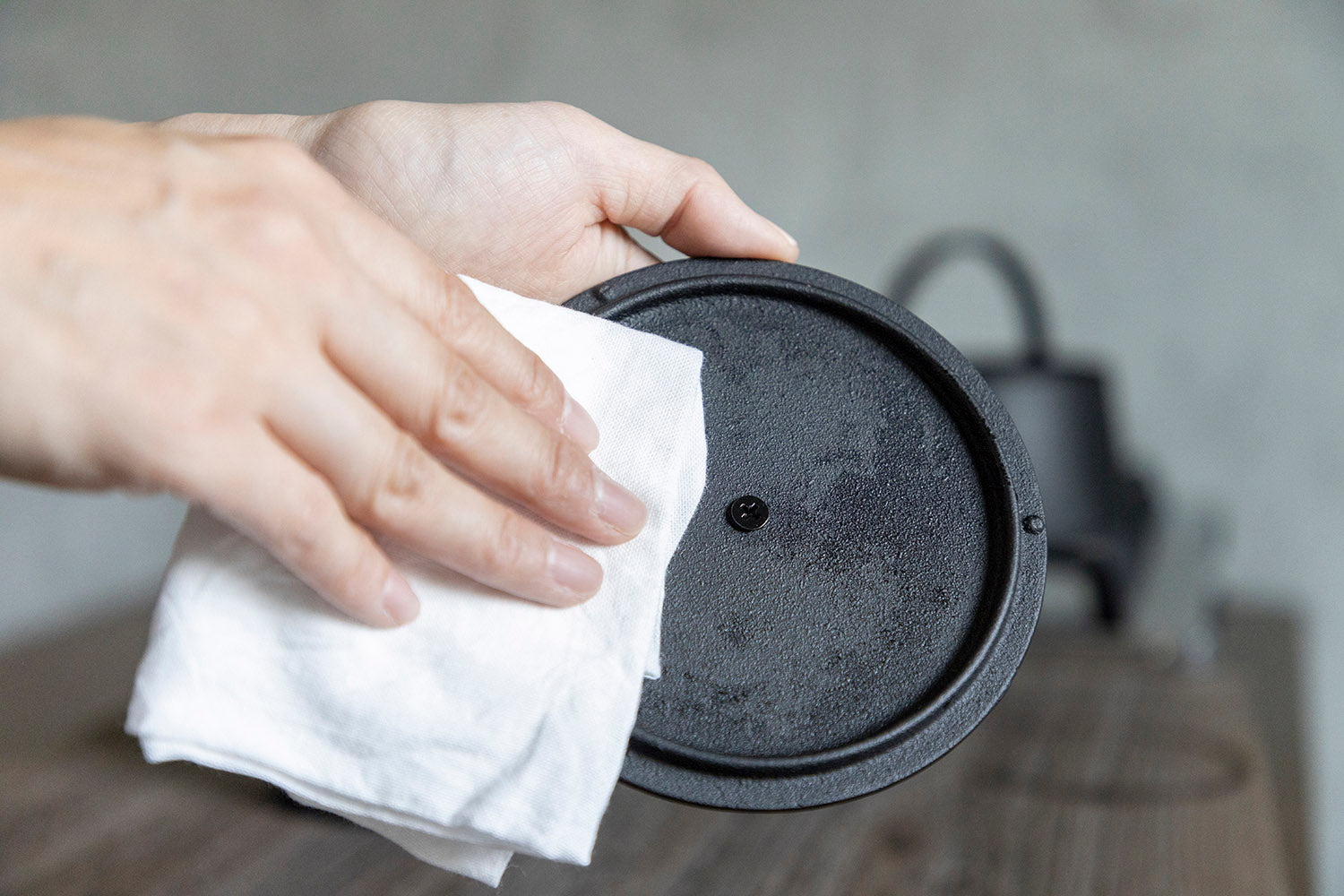 Wiping the lid of an iron kettle or teapot
