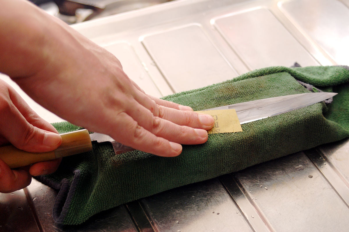 Polish the middle flat part of the knife. For this, use sandpaper or abrasive film, not whetstones.