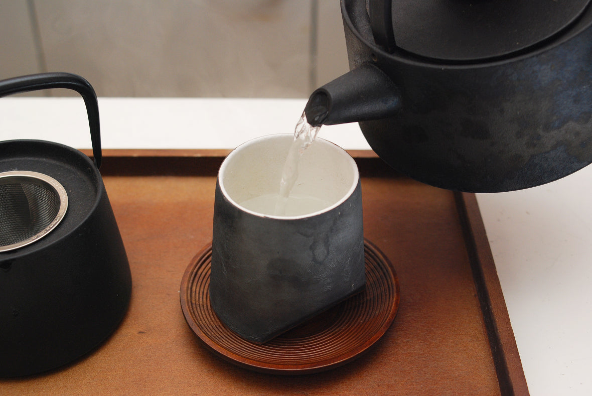 Pour hot water from Tetsubin to each teacup. This is to cool hot water and pre-warm teacups.