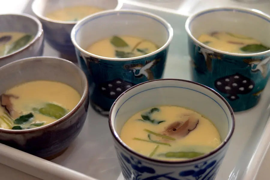 After placing the chawanmushi in the steamer, cover it up with the lid. Steam them in high heat for 3 minutes. Turn down the heat to low and steam them for about another 10 minutes. When the egg is solidified and has a smooth surface, it's done.