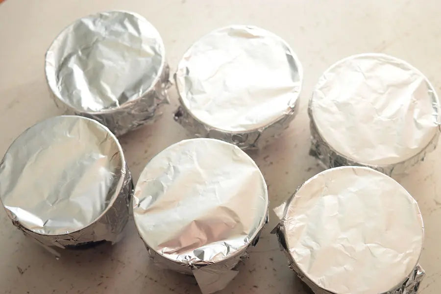 After placing the ingredients and the mixture, cover the teacups with aluminum foil.