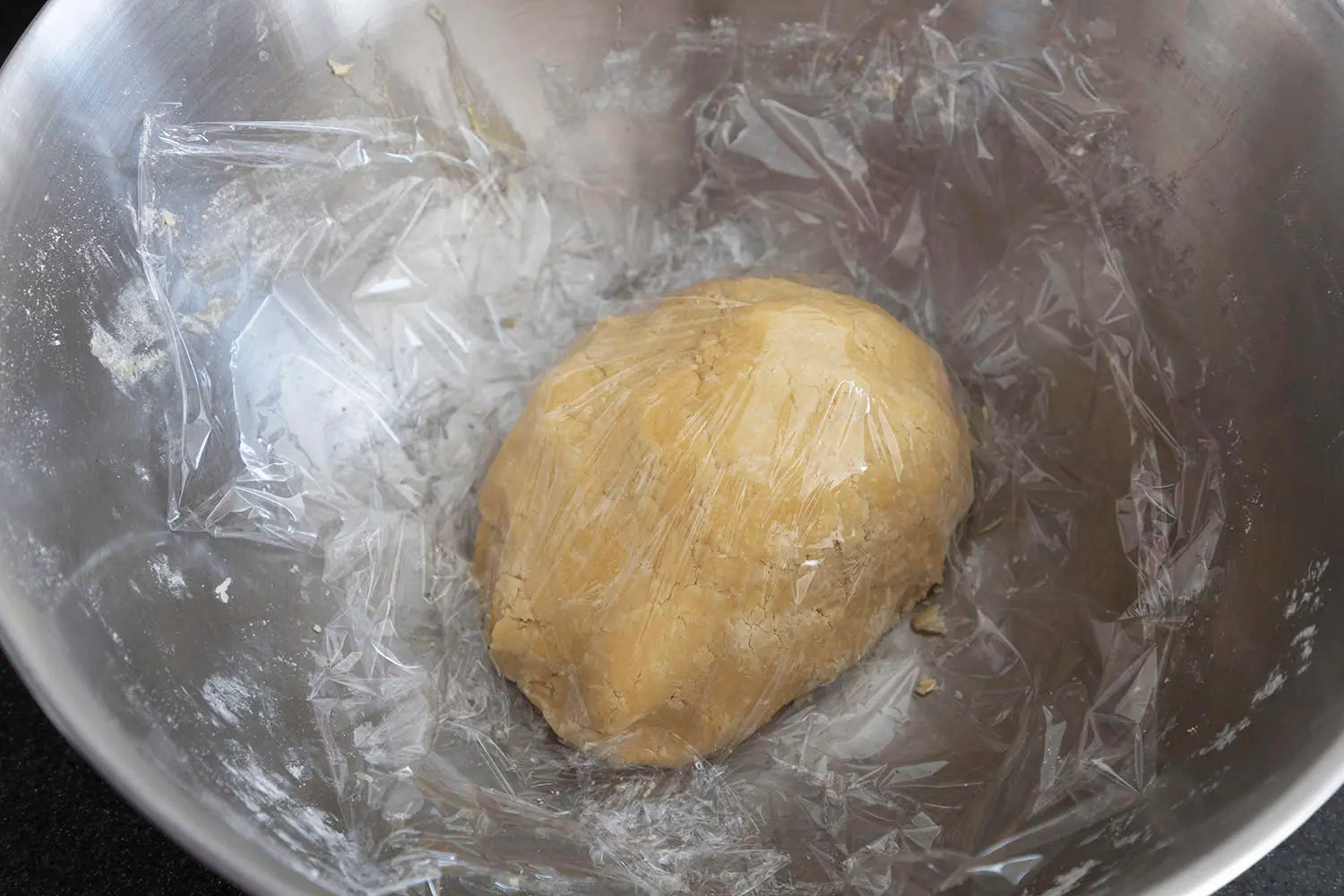 Covering cookie dough with plastic wrap