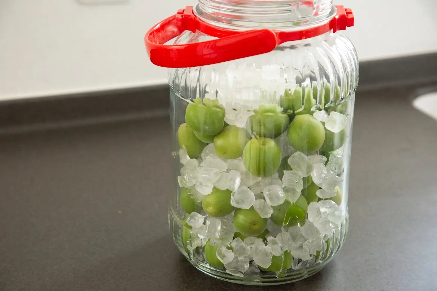 Plums and sugar placed in layers inside bottle