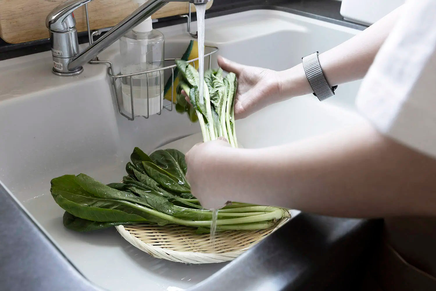 bamboo colander being used to wash vegetables