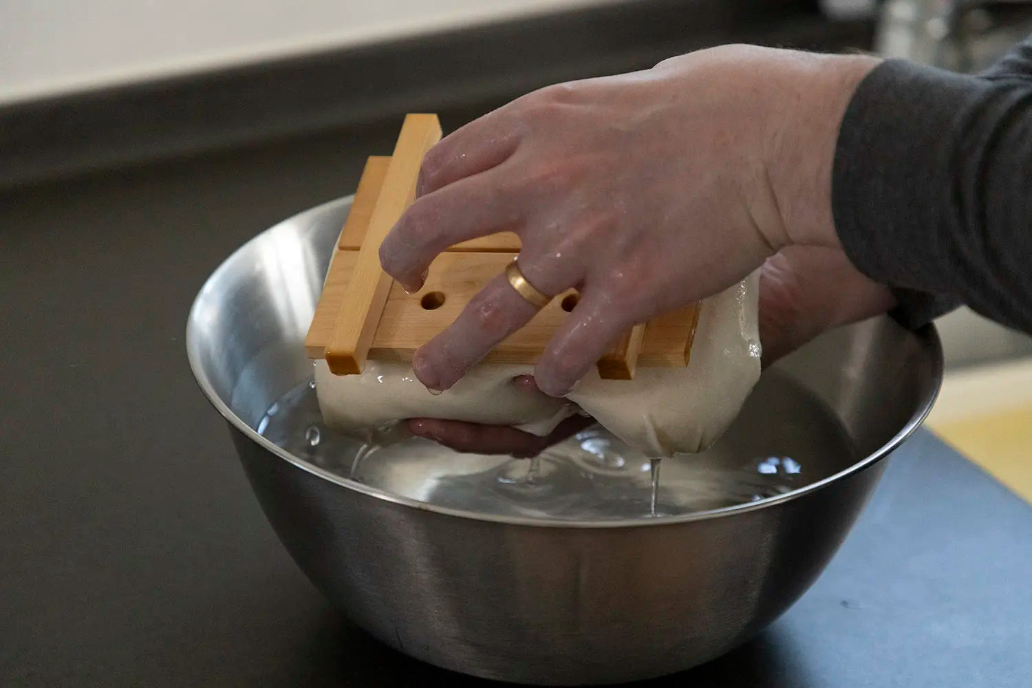Placing tofu in bowl of water