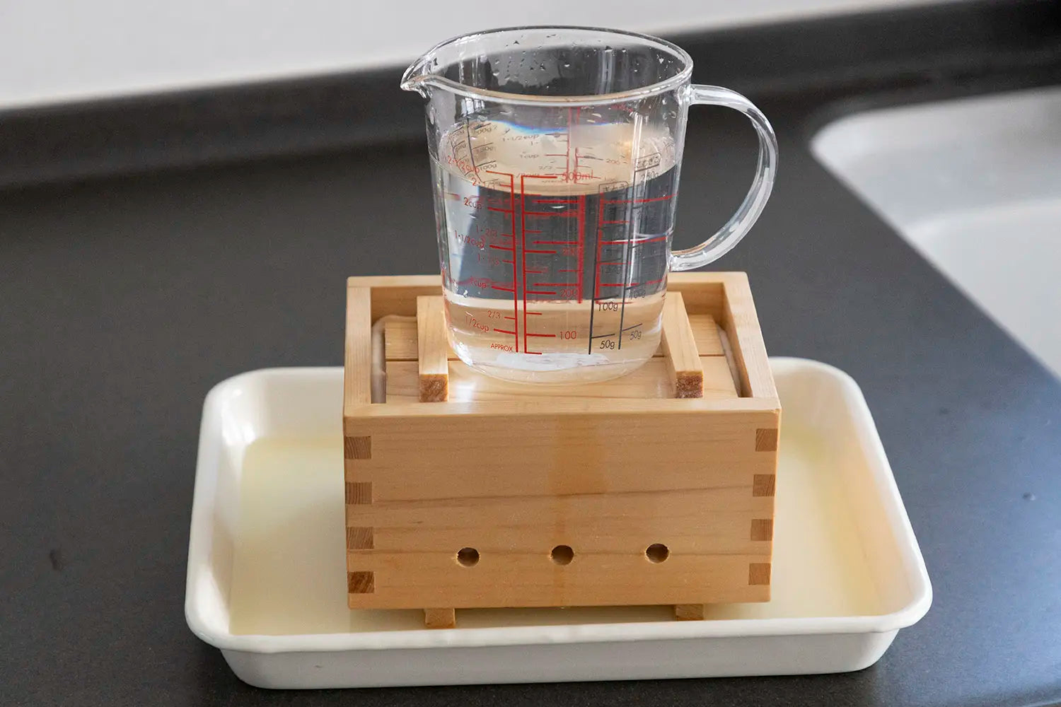 Placing lid and weight on top of tofu