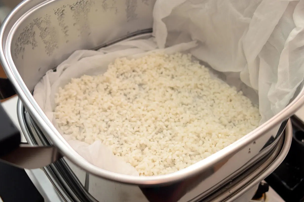 Set up a steamer and bring the water to a boil. Place the drained mochi rice in the steamer and steam it.