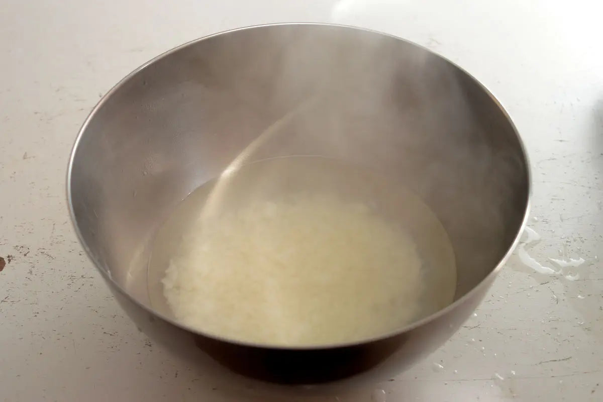 Place the steamed rice in a mixing bowl, add hot water and leave it for about 5 minutes.