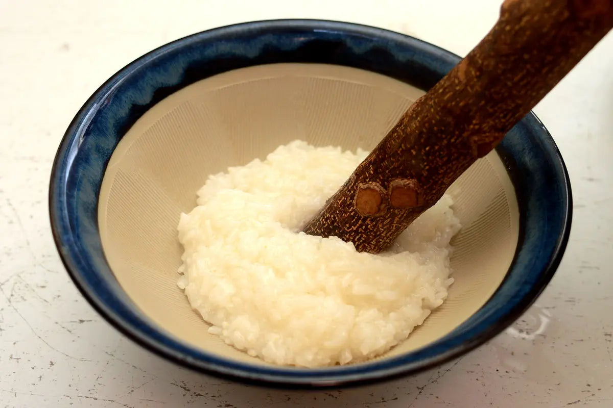 Place the steamed rice in a suribachi mortar and pound or mash it with a surikogi pestle.