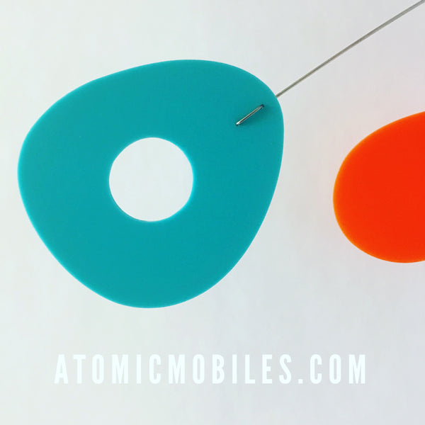 Primer plano del móvil artístico colgante ModCast de AtomicMobiles.com en aguamarina, naranja y lima