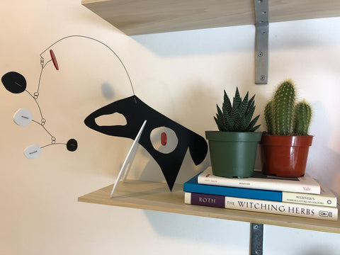 Modern art stabile sculpture - The Dog - by AtomicMobiles.com with books and succulent and cactus plants