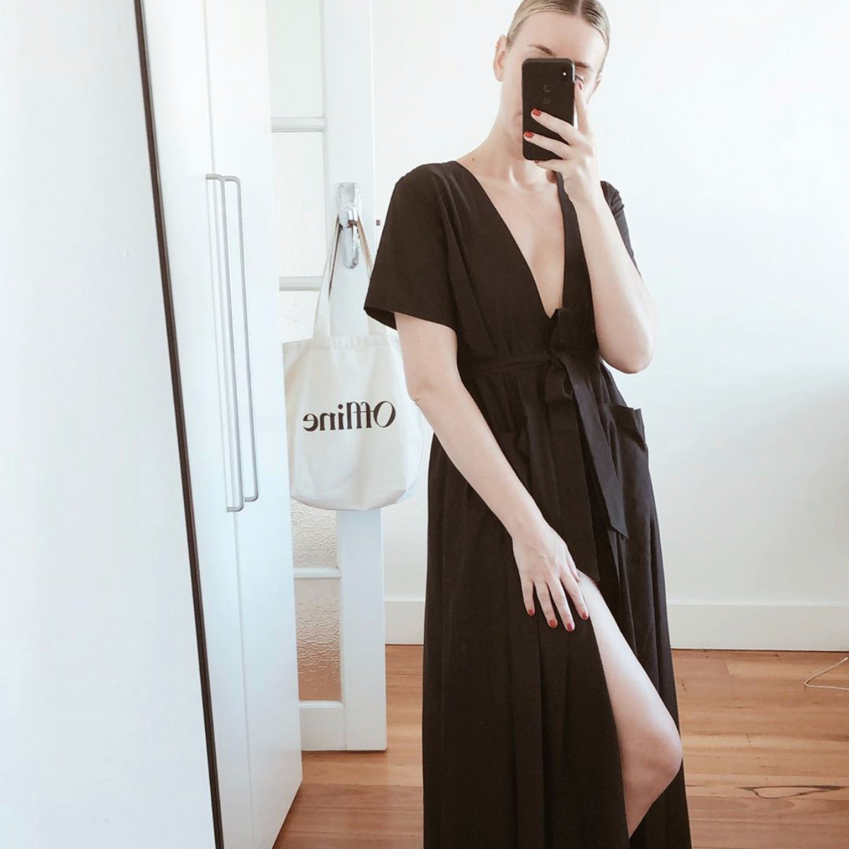 Alison Larsen Rice takes selfie in mirror wearing black maxi resort dress by Robe luxury resort wear