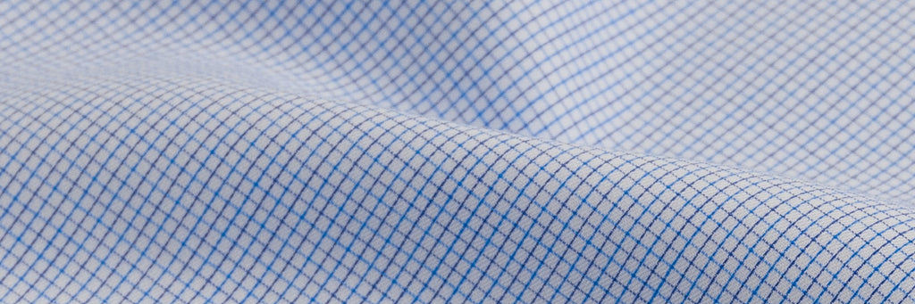 Close up of a men's button down dress shirt with a small blue check pattern