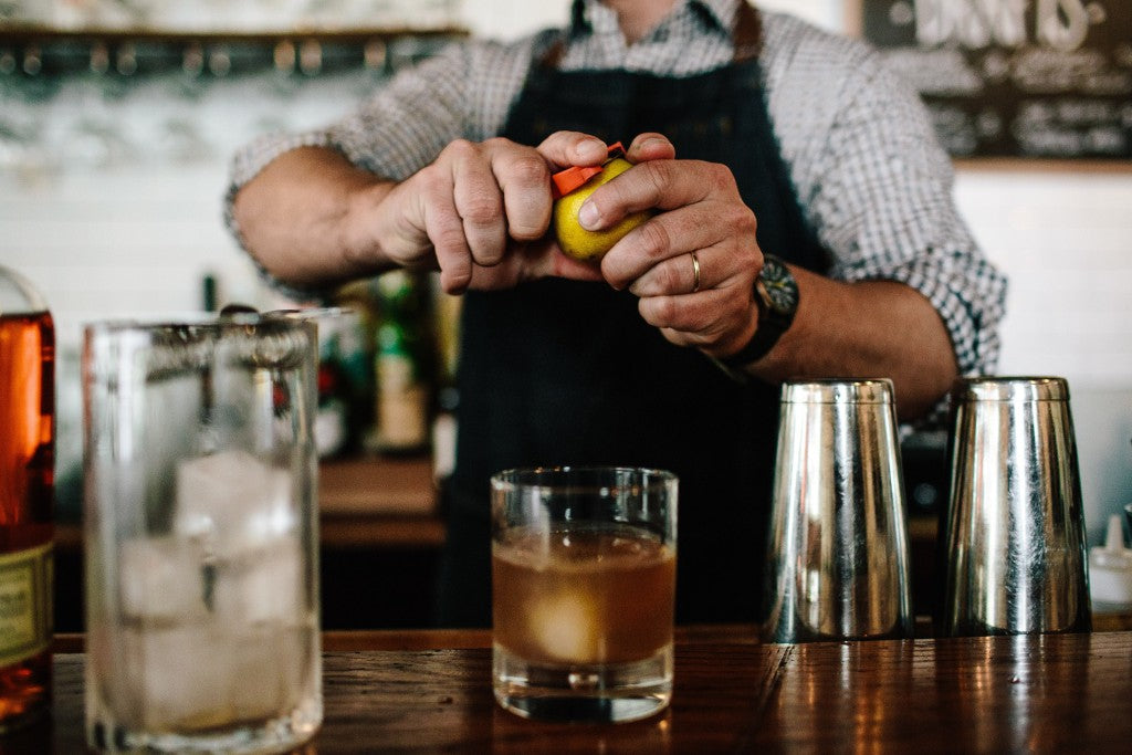 Bartender finishing an old fashioned cocktail made with bulleit bourbon
