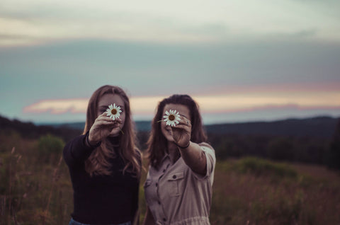 Two girls holding sunflowers.