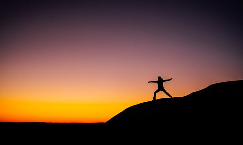 A person on a mountain stretching.