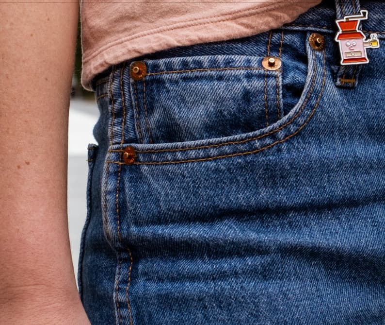 Jeans with an enamel pin attached to the belt loop