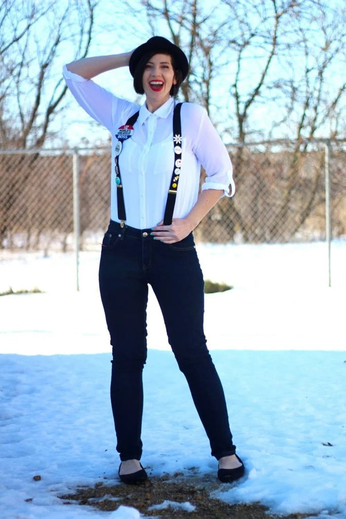 Woman wearing suspenders with enamel pins attached