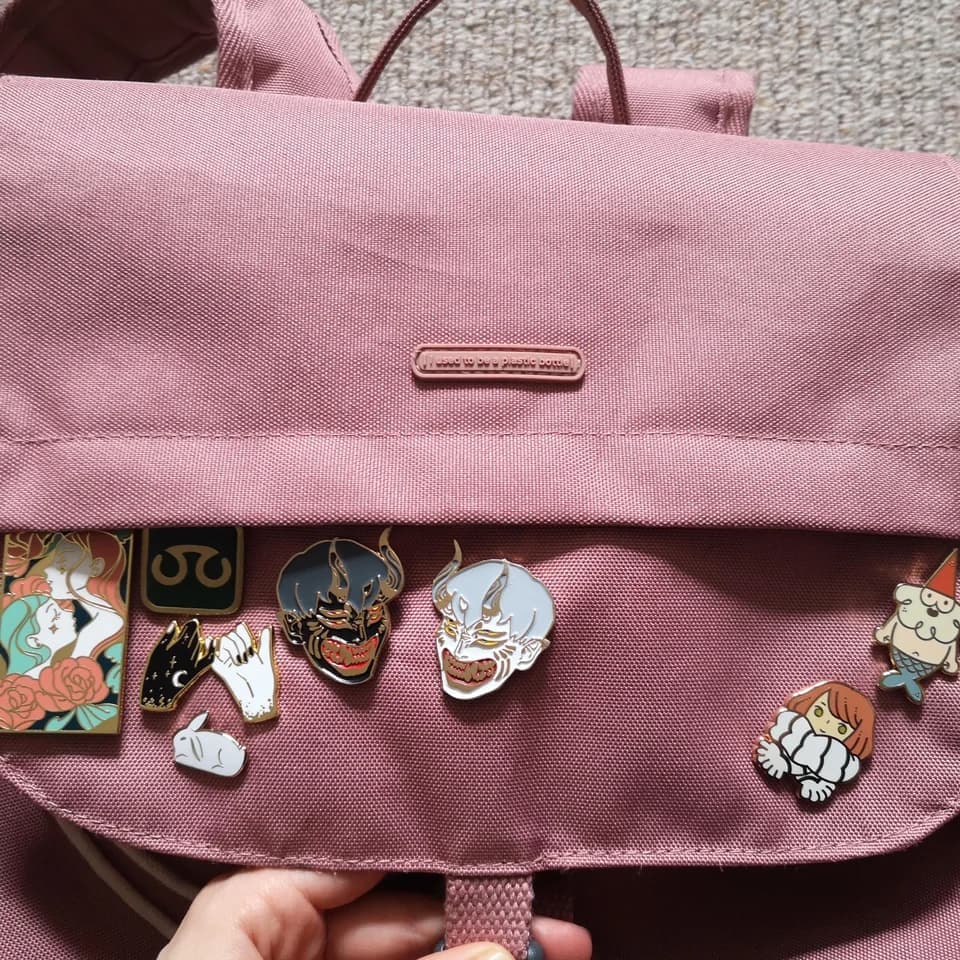 a bag with several enamel pins attached