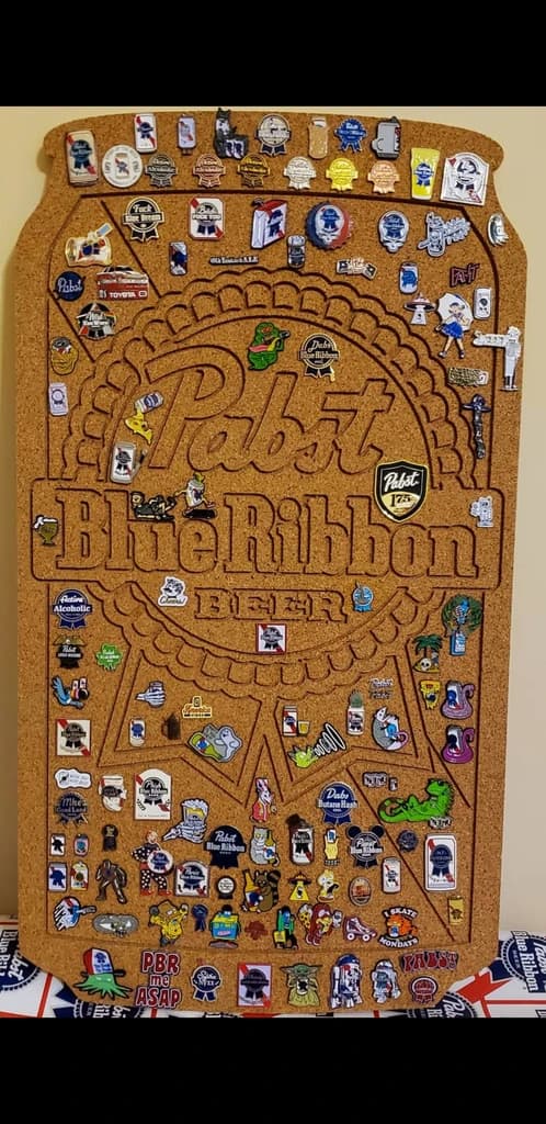 A corkboard with several enamel pins attached