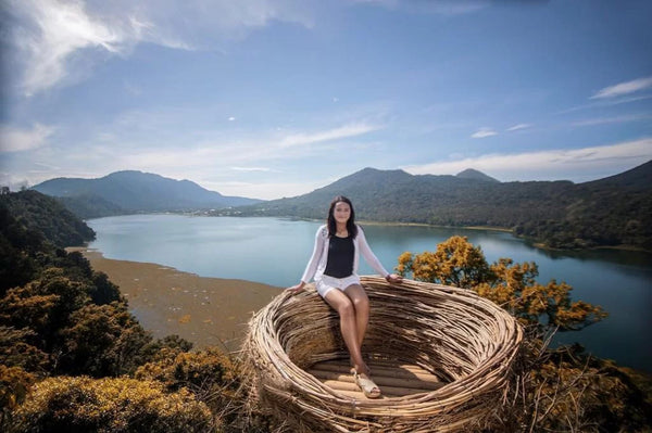 seorang wanita berfoto di spot foto sangkar burung wanagiri hidden hills