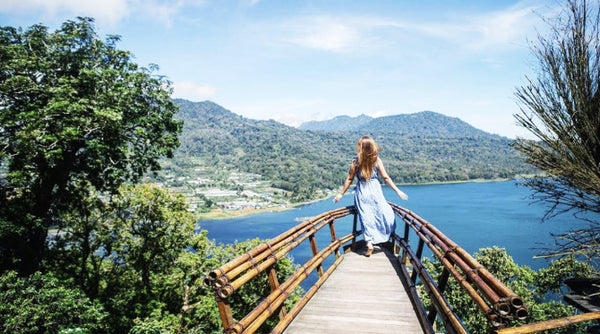 seorang wanita berfoto di spot foto jembatan kayu wanagiri hidden hills