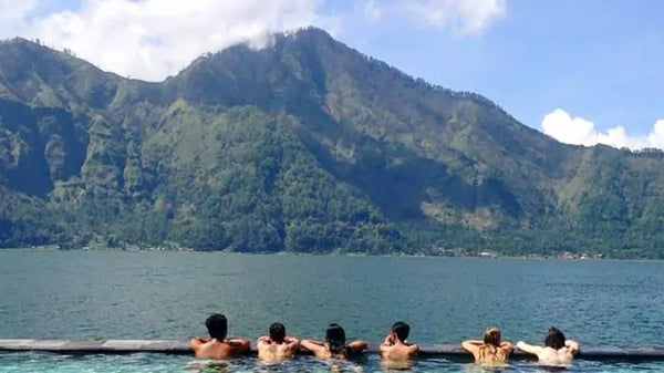 beberapa orang sedang berendam di toya bungkah sambil menikmati pemandangan gunung batur