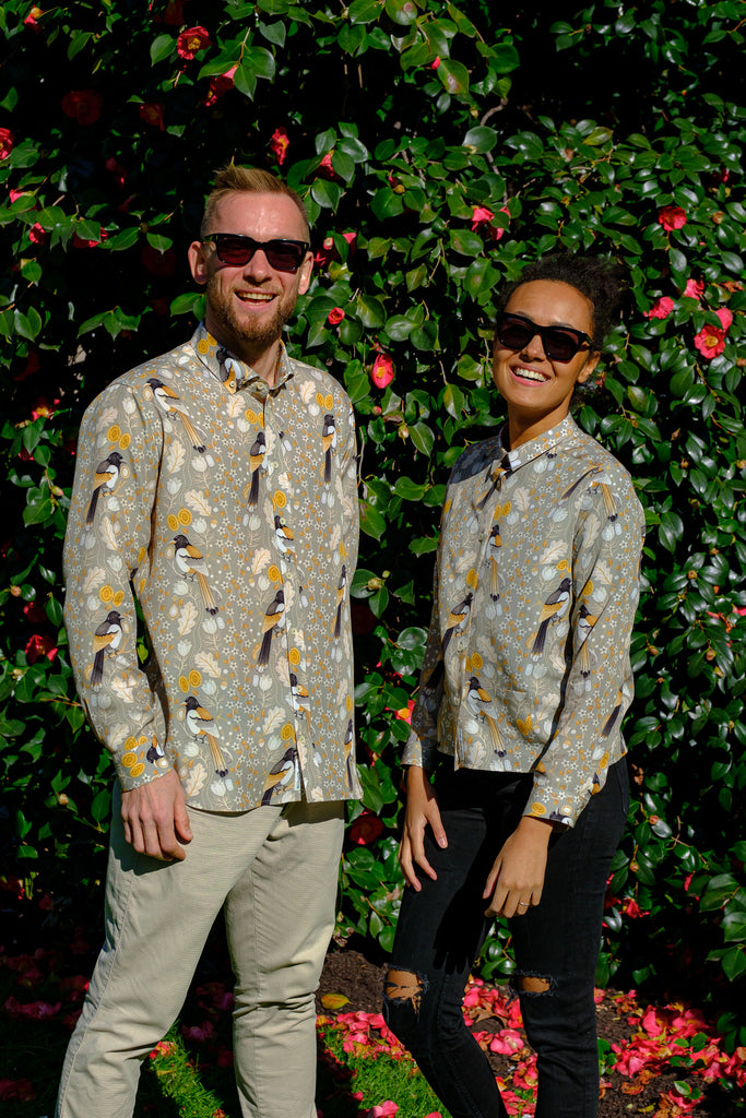 A close-up photo of an elegant shirt with a print of magpies and jewels, made from Tencel (Lyoncell) fabric. The shirt has a smooth texture and a slight sheen, and is shown on a hanger against a neutral background.