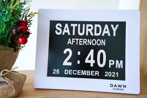 Dawn Clock sits on a table next to a Christmas decoration. The Dawn Clock is a great Christmas gift for hose hard to buy for. 