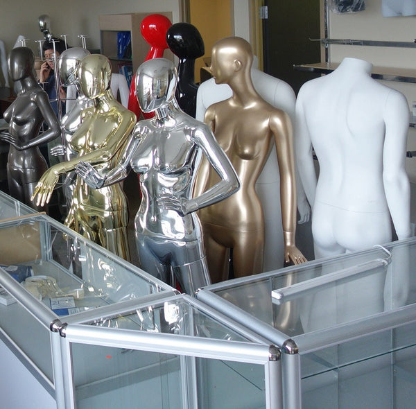 attractive mannequins behind shop counter 