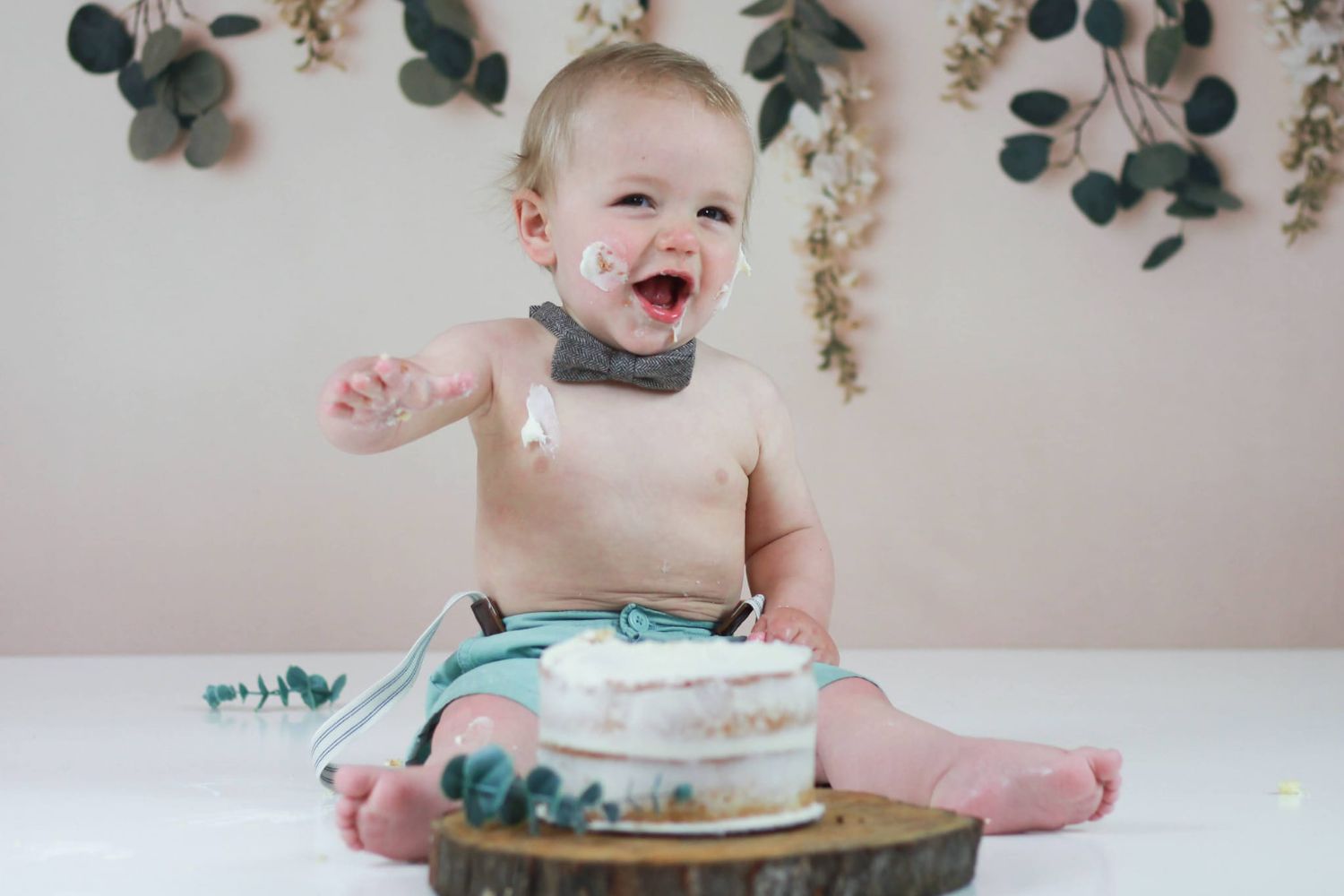 baby boy's cake smash with a bohemian garland