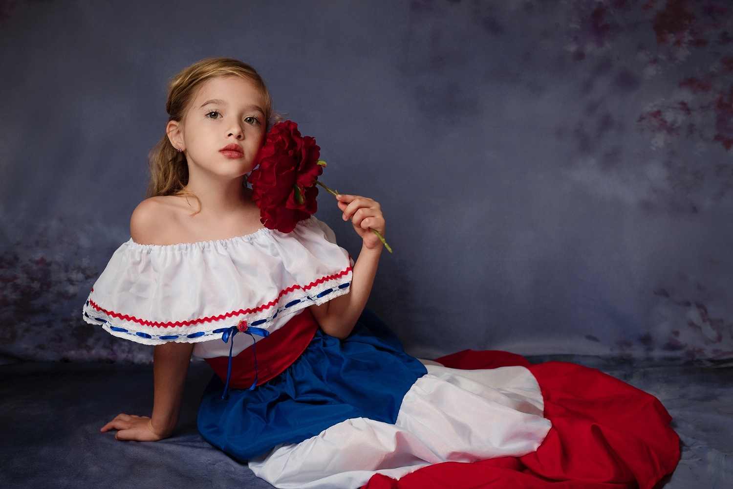 a girl is taking photo by sitting on the floor