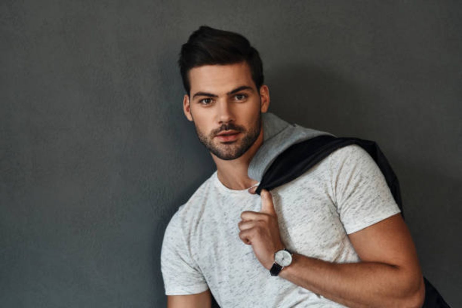 a man is taking a sitting photo by tossing his jacket over the shoulder