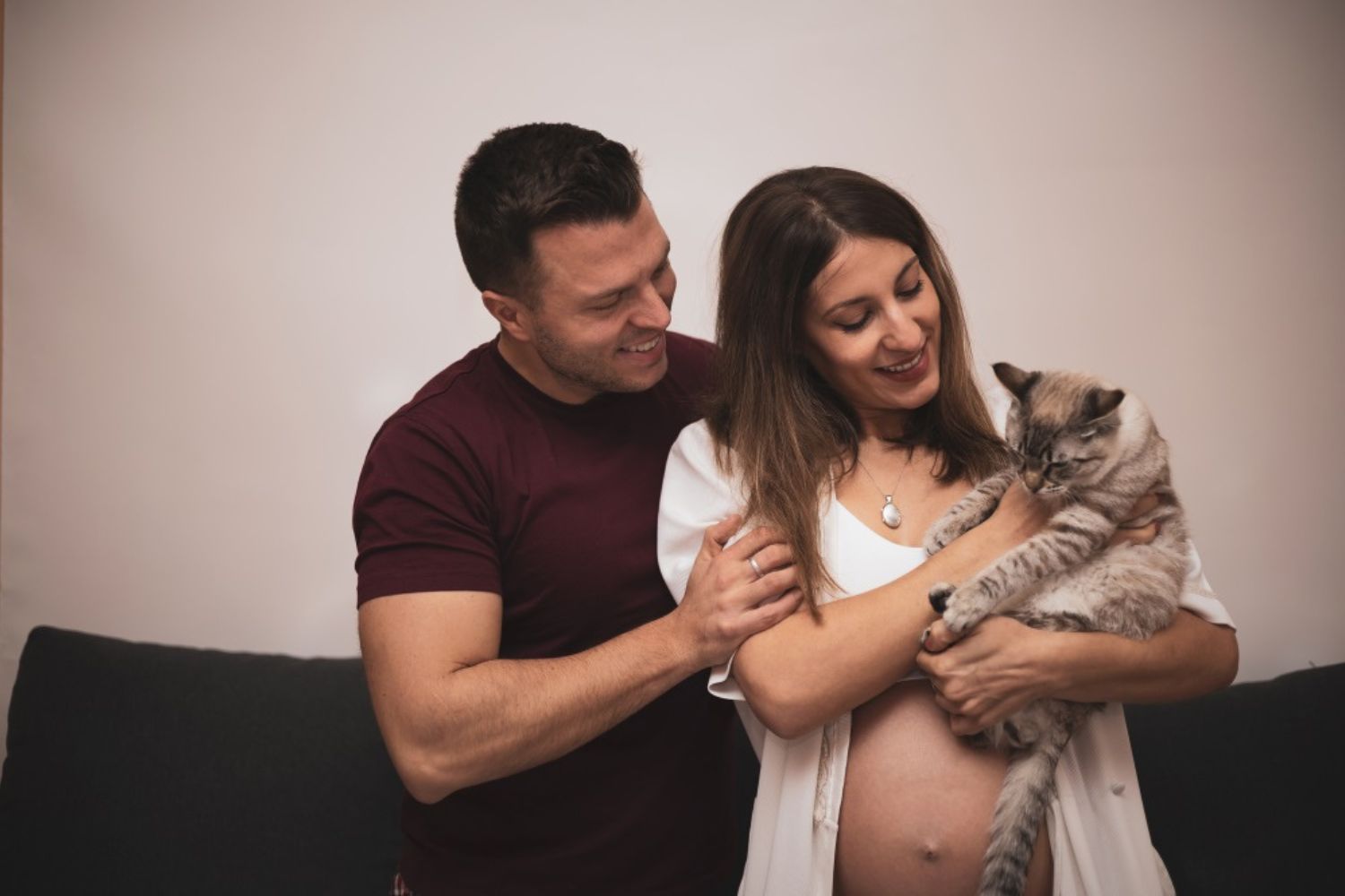 couple maternity photo by holding lovely pet