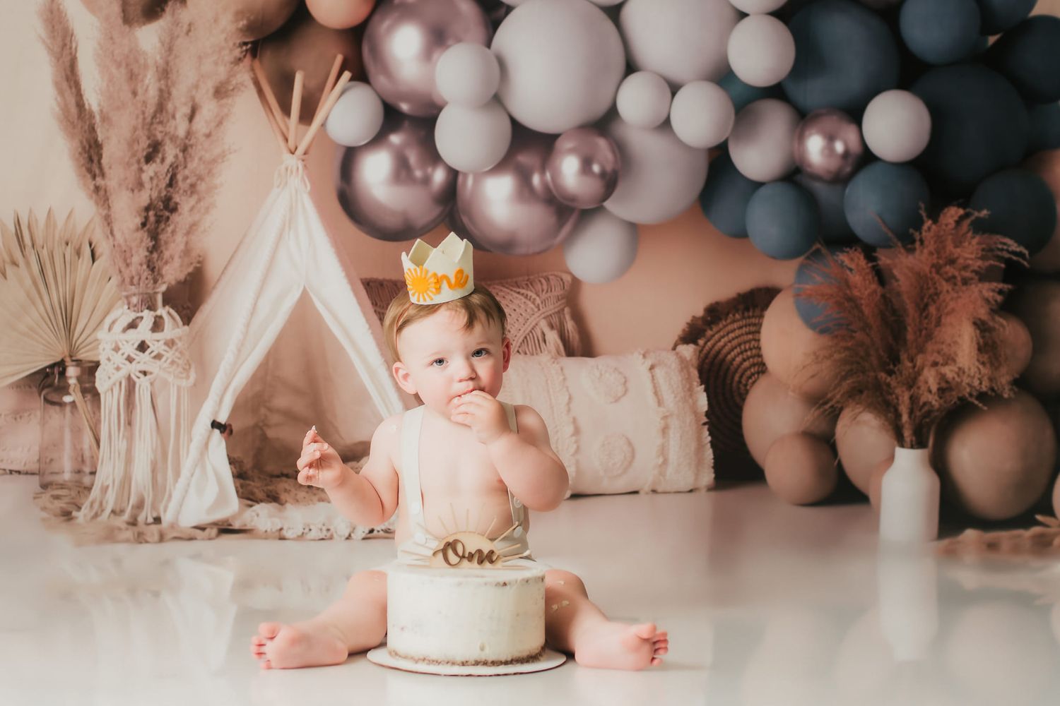 baby boy's cake smash with boho balloon decorations
