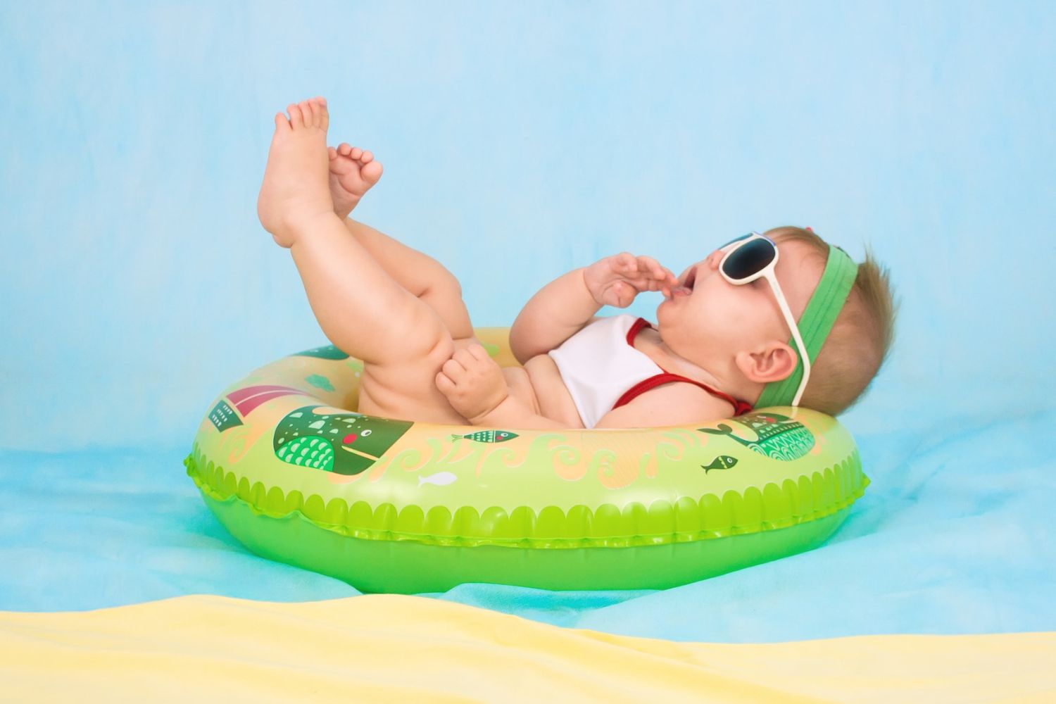 baby boy lying on green lifebelt