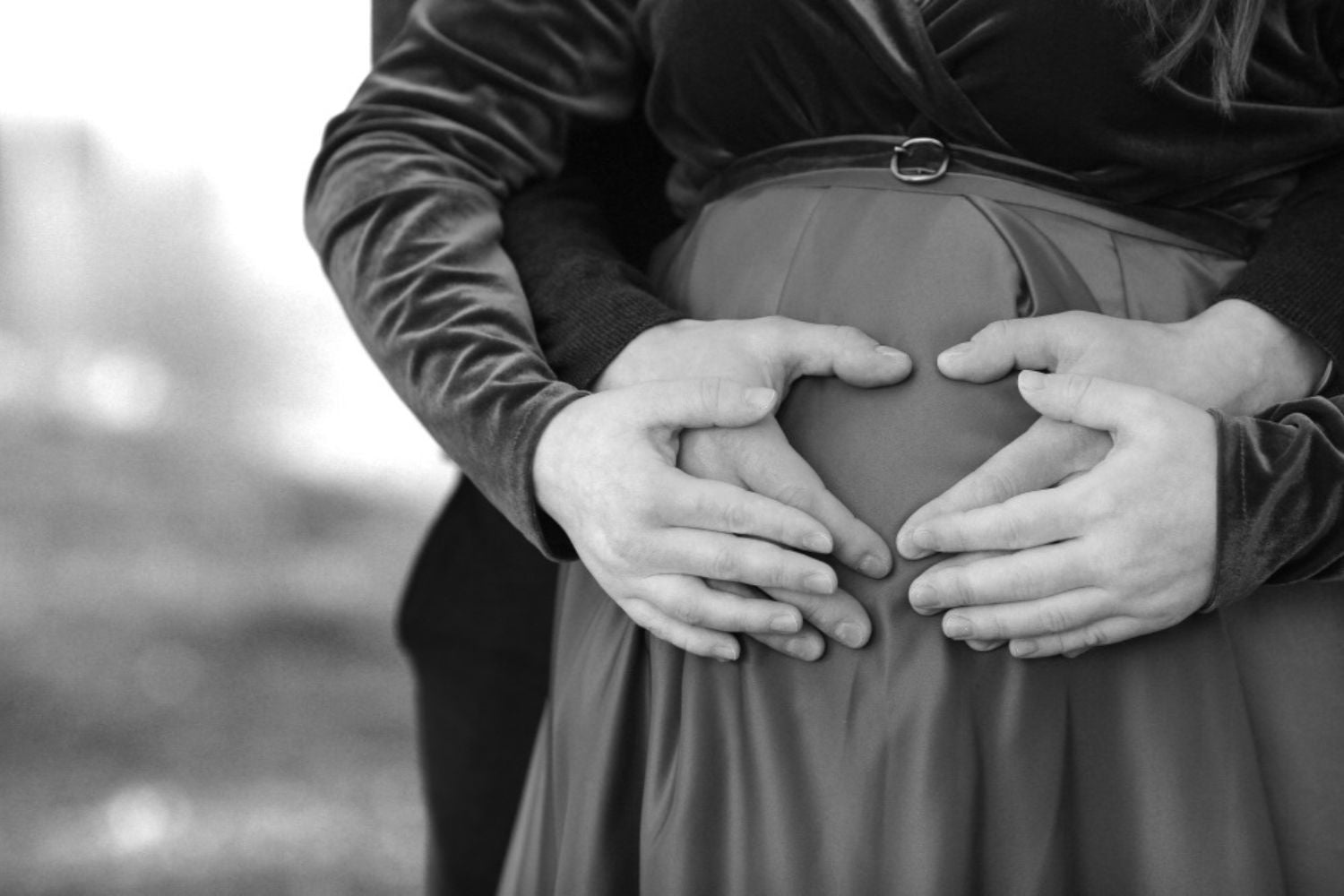 black and white maternity photo by putting a hear-shape on the belly