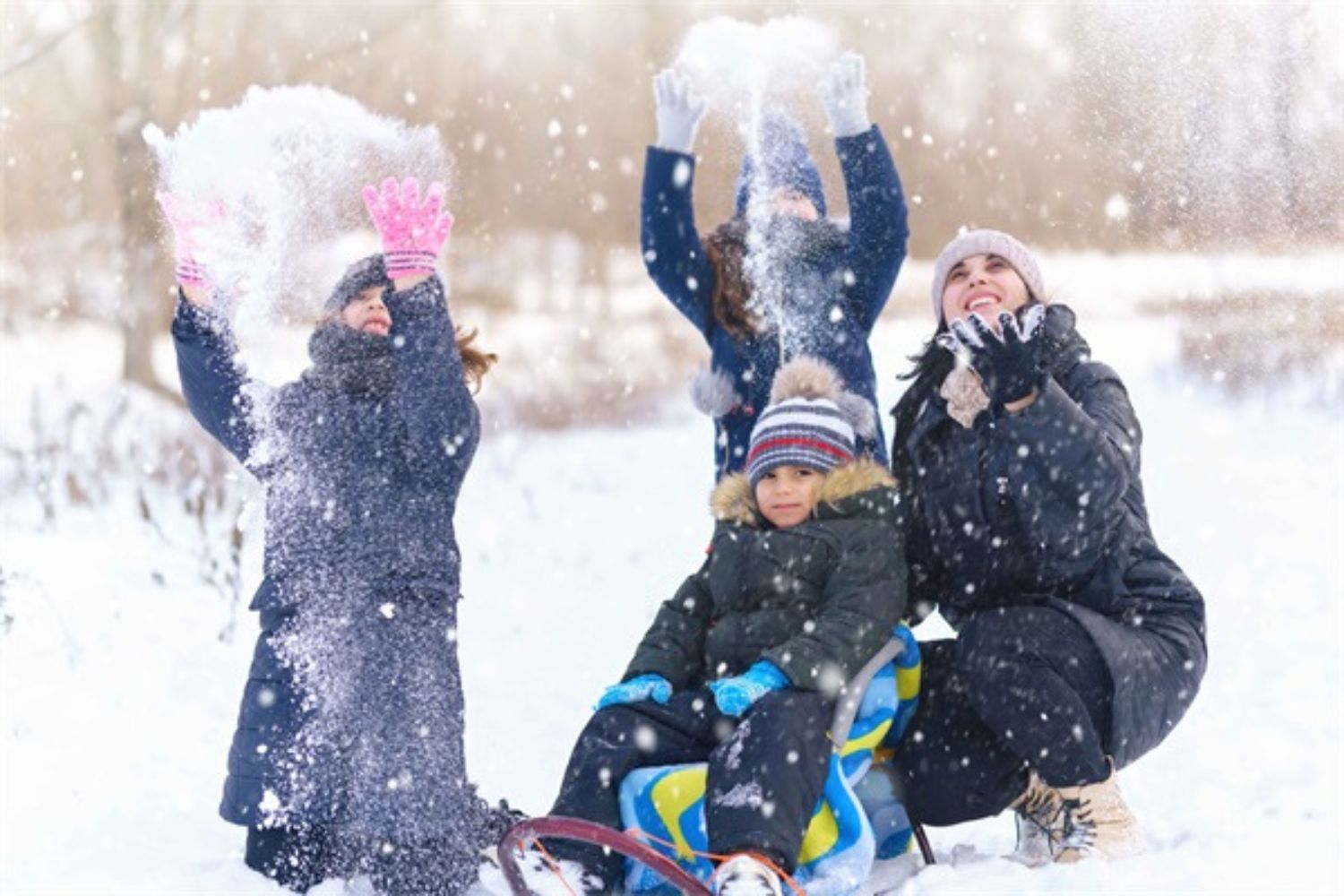 mum and kids playing snow in the yard