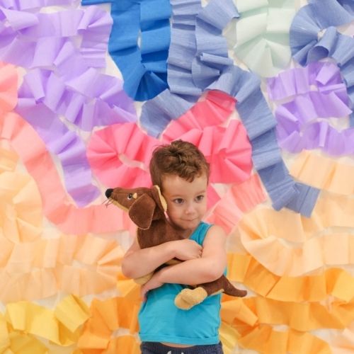 a boy’s photo with Crepe Paper Photo Backdrop