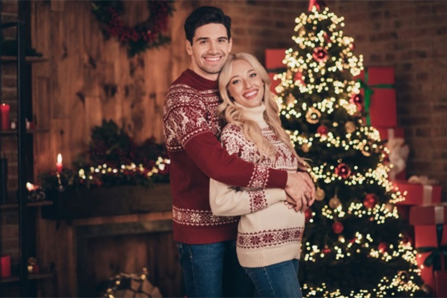 couple maternity photo by standing  with Christmas lights